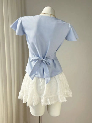 Blue striped polyester blouse with flutter sleeves and tie back, paired with a white lace skirt.
