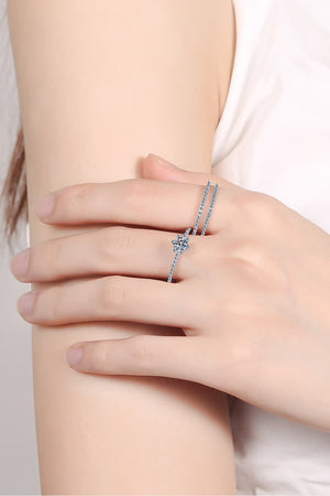 Silver ring trio with a central flower-shaped stone and delicate band.