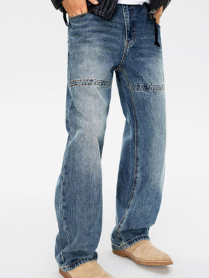 Men's relaxed fit blue denim jeans with vintage wash and panel detail at the knee.