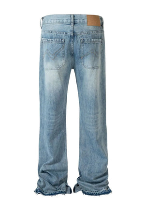 Medium wash denim jeans with distressed details and split hem.