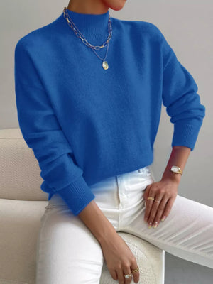 Blue mock neck knit sweater with dropped shoulders and ribbed cuffs.