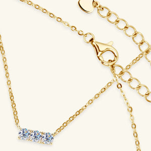 Gold bar necklace with three moissanite stones and a lobster clasp.