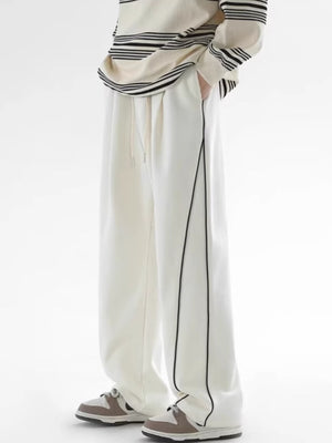 Men's white relaxed fit sweatpants with black side stripes and drawstring waist.