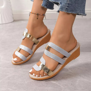 Glistening dual-strap wedge sandals in silver and gold with a cork wedge heel.