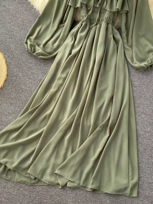 Green maternity dress with ruffled square neck, smocked bodice, balloon sleeves, and flowy A-line skirt.