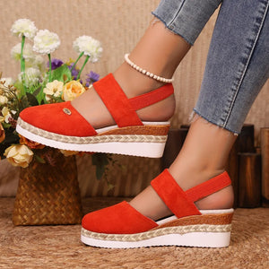 Orange espadrille wedge slingback sandals with elastic straps and espadrille trim.