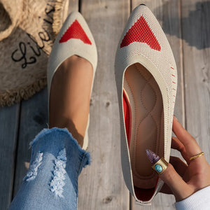 Beige knit pointed flats with red geometric pattern detail and red trim.