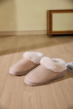 Suede house slippers with plush shearling trim in beige.
