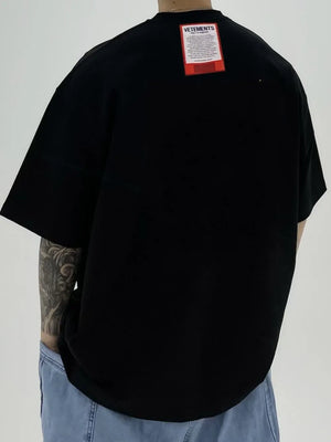 Black oversized t-shirt with red VETEMENTS tag on back.