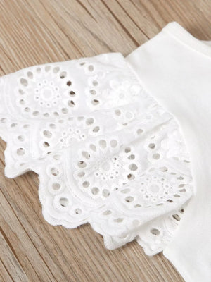 White cotton baby outfit with delicate eyelet lace flutter sleeves and scalloped hem.