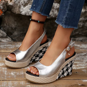 Sleek open-toe wedge sandals in silver with a decorative buckle and houndstooth wedge.
