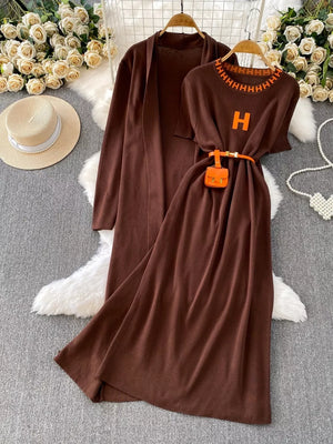 Brown knitted maxi dress and cardigan set with orange 'H' detail and belt.
