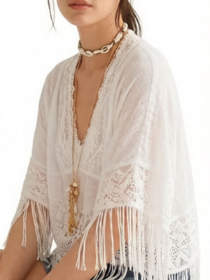 White bohemian lace cover-up with fringe and V-neck, styled with necklaces.