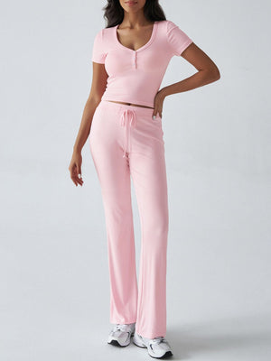 Blush pink button-front crop top with short sleeves and flared lounge pants with drawstring waist.