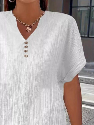 White textured v-neck t-shirt with decorative buttons and short sleeves.