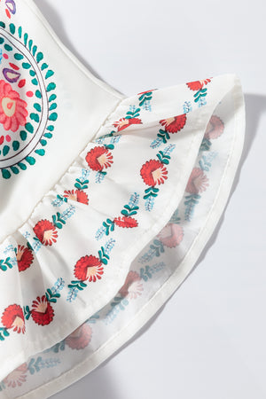 Embroidered medallion peplum blouse in floral with ruffled trim and red floral print.