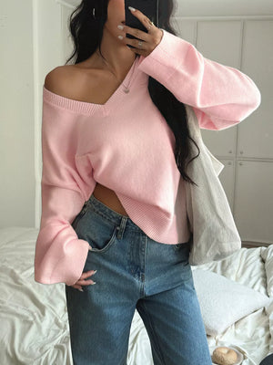 Blush pink acrylic V-neck knit sweater with relaxed fit and bell sleeves.