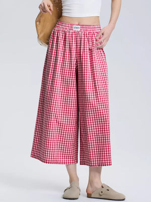 Gingham check wide-leg maternity pants in rose red with an elastic waistband.