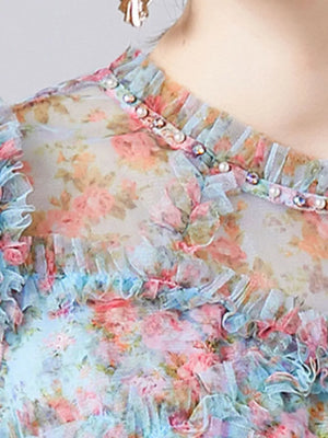 Sheer floral dress with ruffled neckline and pearl and crystal embellishments.