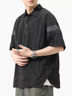 Black quarter-zip polo with short sleeves, contrast shoulder detail, and chest pocket.