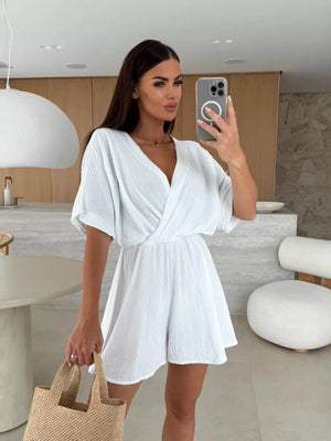 White twist-detail V-neck romper with dolman sleeves and cinched waist, casual style.