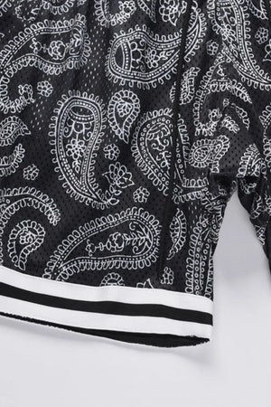 Black mesh basketball shorts with white paisley pattern and striped hem.
