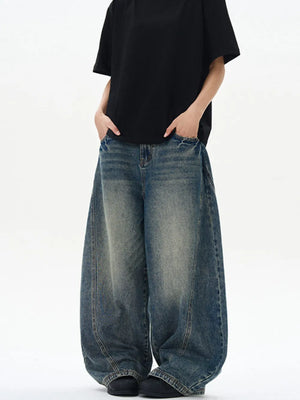 Oversized vintage-finish men's baggy jeans in dark wash denim with distressed details.