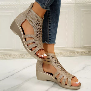 Gold cutout ankle cuff wedge sandals with glitter accents and a zipper closure.