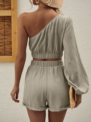 Textured one-shoulder crop top and cuffed shorts set in beige.