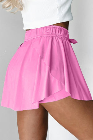 Fuchsia pink ruffled skort with tie waist detail and elastic waistband.
