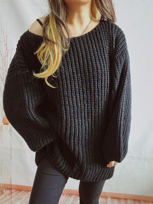 Black oversized ribbed knit sweater with a dropped shoulder and wide sleeves.