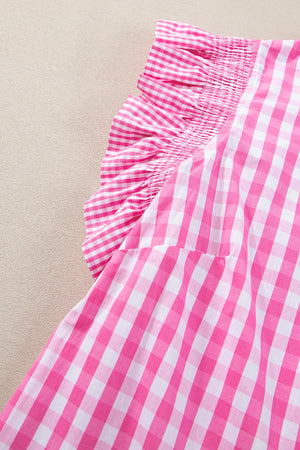Fuchsia pink gingham blouse with smocked neckline and ruffle sleeves.