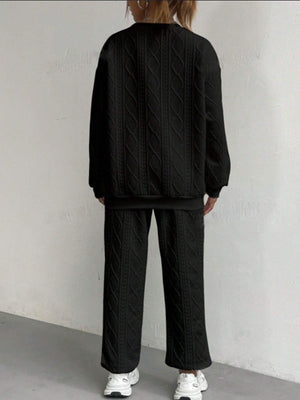 Black cable knit loungewear set with crewneck sweatshirt and wide-leg pants.