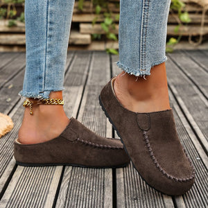 Brown slip-on flats with round toe and contrast stitching detail.