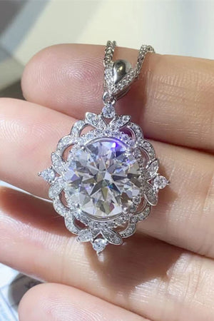 Silver filigree halo diamond pendant necklace with a large center stone and intricate detailing.