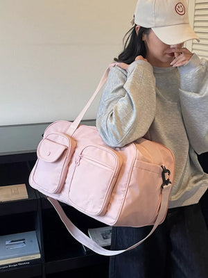 Pink nylon duffle bag with multiple pockets and adjustable strap