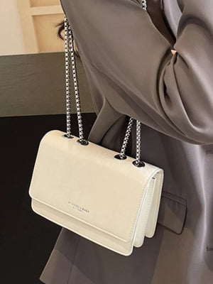 Beige leather shoulder bag with chain strap and crumpled texture detail.