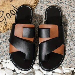 Two-tone brown and black leather crossover toe-loop sandals with white stitching.