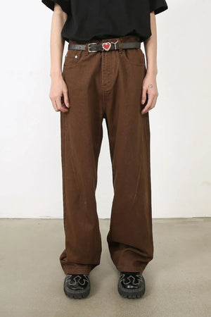 Brown wide-leg denim jeans with angled seams and a belt.