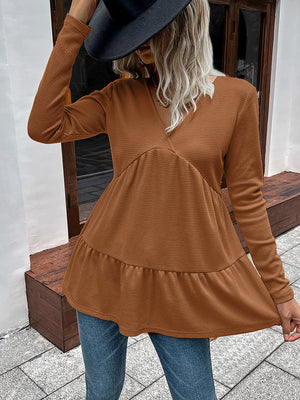 Caramel waffle knit peplum top with V-neck and long sleeves.