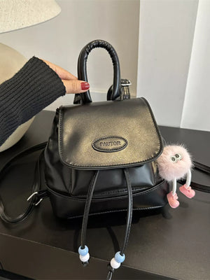 Black leather mini backpack with drawstring closure and beaded details.