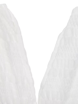 Textured white smocked deep V-neck dress detail.