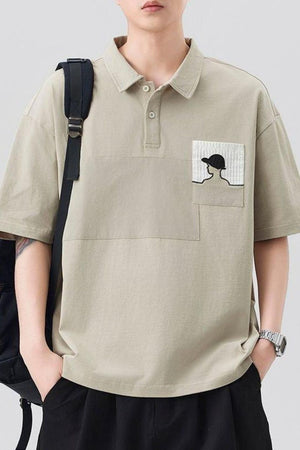 Beige embroidered pocket polo shirt with short sleeves and a buttoned collar.