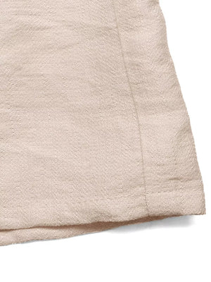 Luxe ruffled V-neck wide-leg romper in beige textured fabric.