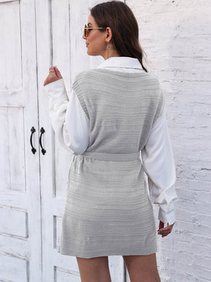 Light Gray knit vest dress with tie and slit detail, styled over a white shirt.
