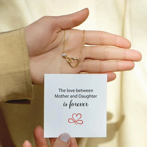 Gold necklace with intertwined heart and infinity pendant with a single clear stone.