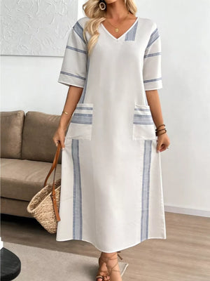 White maxi dress with blue stripes, V-neck, short sleeves, and pockets.