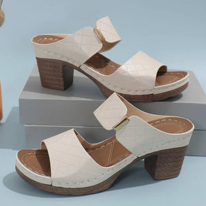 Ivory quilted leather platform mules with block heel and gold buckle detail.