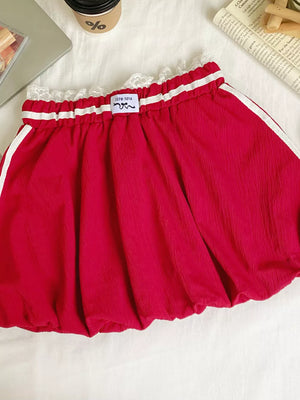 Red mini skirt with lace trim, gathered waist, and white side stripes.