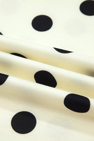 Polyester t-shirt with black polka dots on a cream background, showing fabric texture.